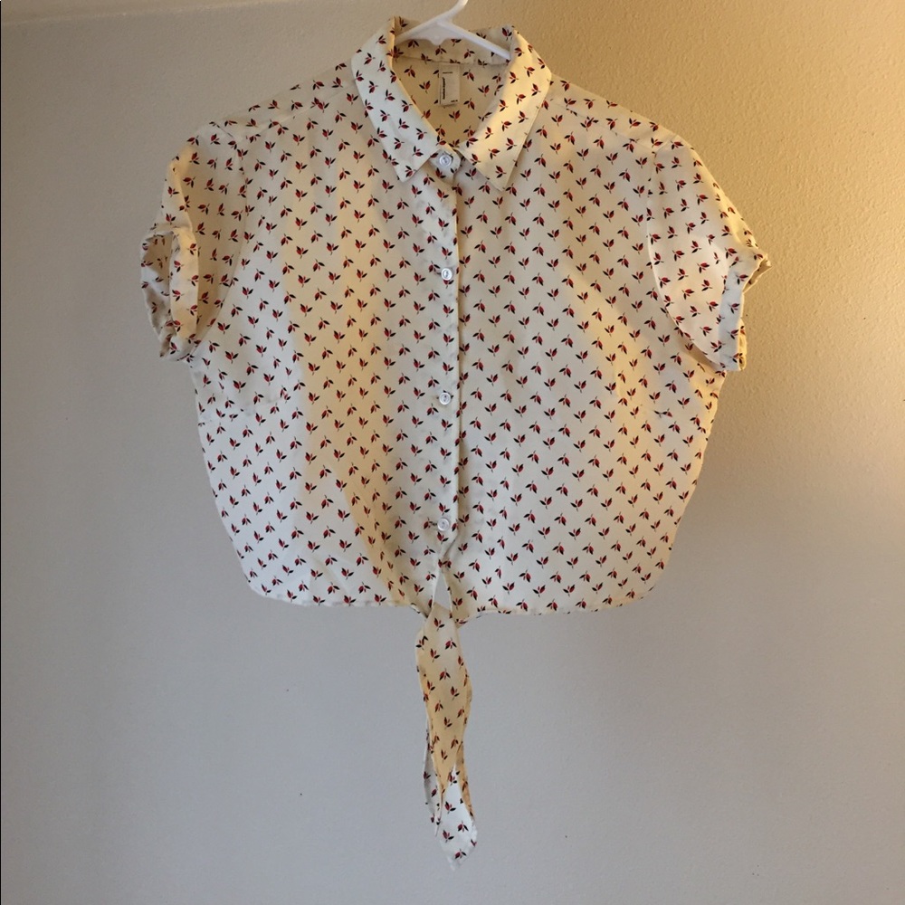 Creme patterned, mid-length blouse.