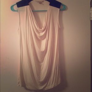 White cowl neck, sleeveless blouse with leather.