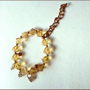 Gold toned resin bracelet with lock and key charms