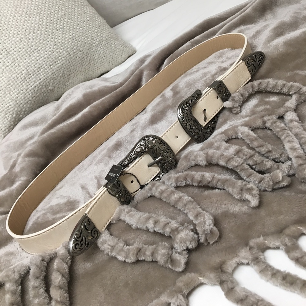 Cream western belt with silver embellishments.