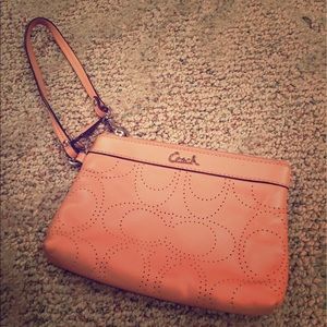 Blush colored coach wristlet.