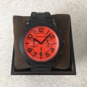 MK wrist watch with orange face.