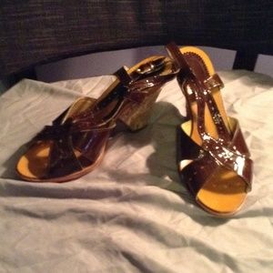 Brown patent strapped wedge shoes.