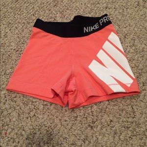 Neon orange/ coral Nike pros with Nike label