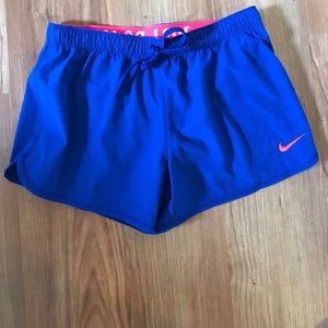 Blue nike running shorts with hot pink lining.