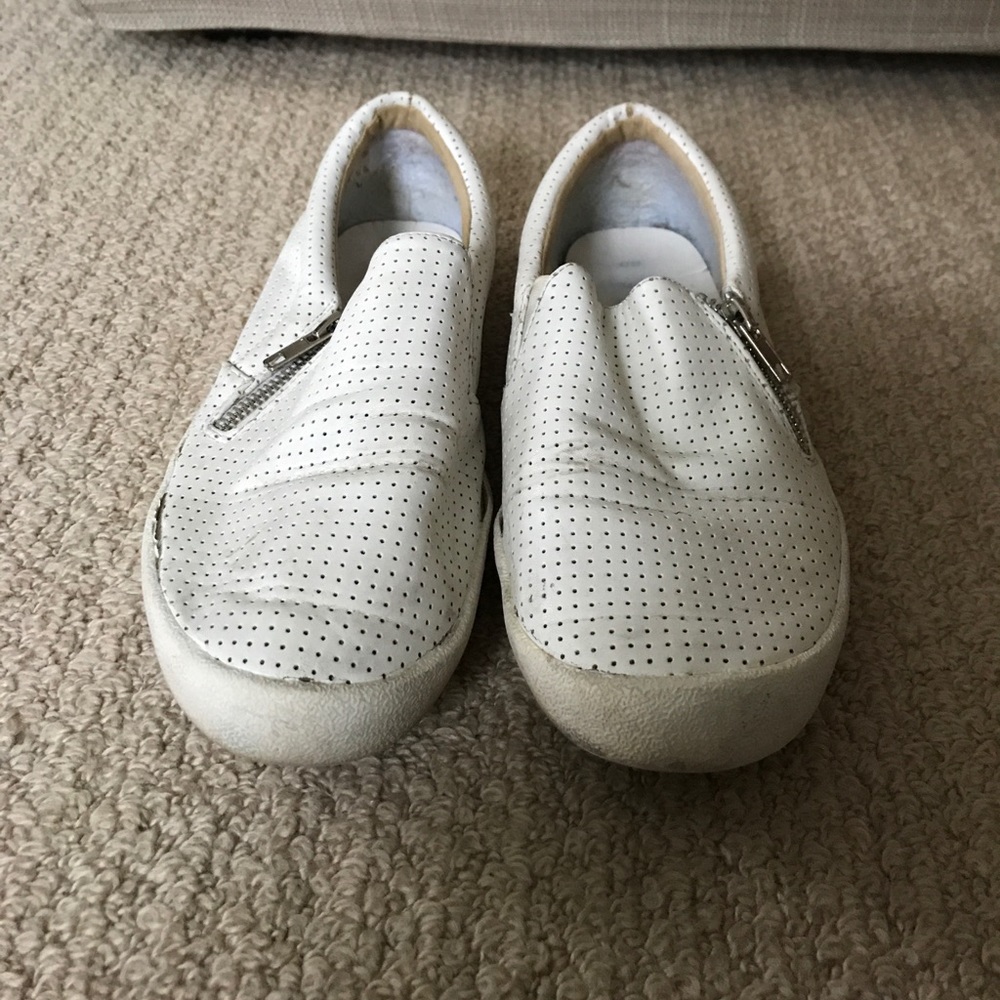 Slip on white sneakers, no ties, zips.