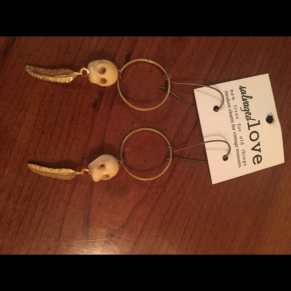 Bone skull earrings with gold toned metal feather