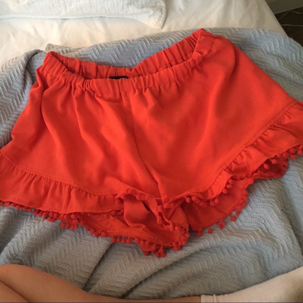 orange pompom trim ruffle shorts