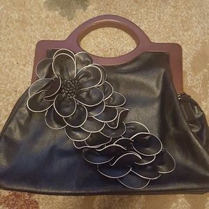 Black purse with flower detail and wooden handle