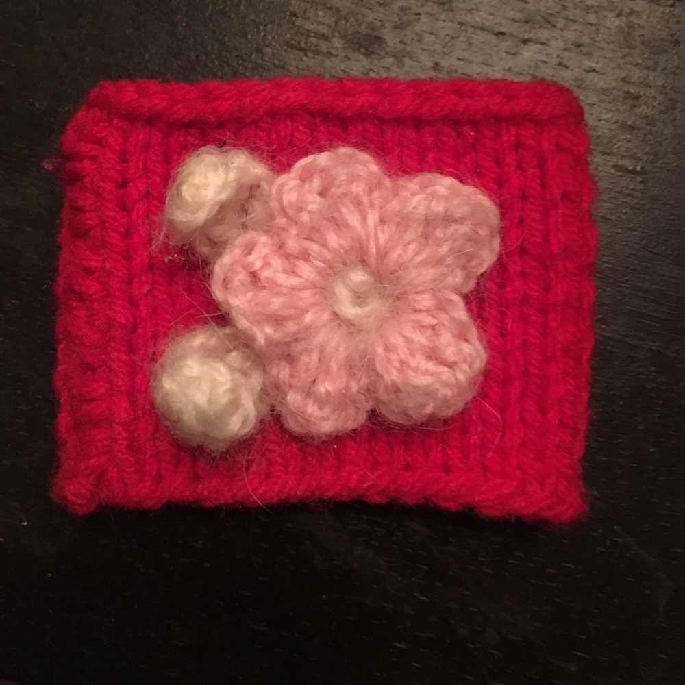 Hand knit red cuff with mohair flower accent