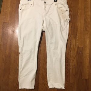 Ankle-length white pants with a raw hem.