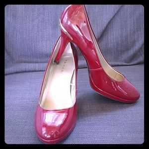 Red patent leather pumps with gold trim