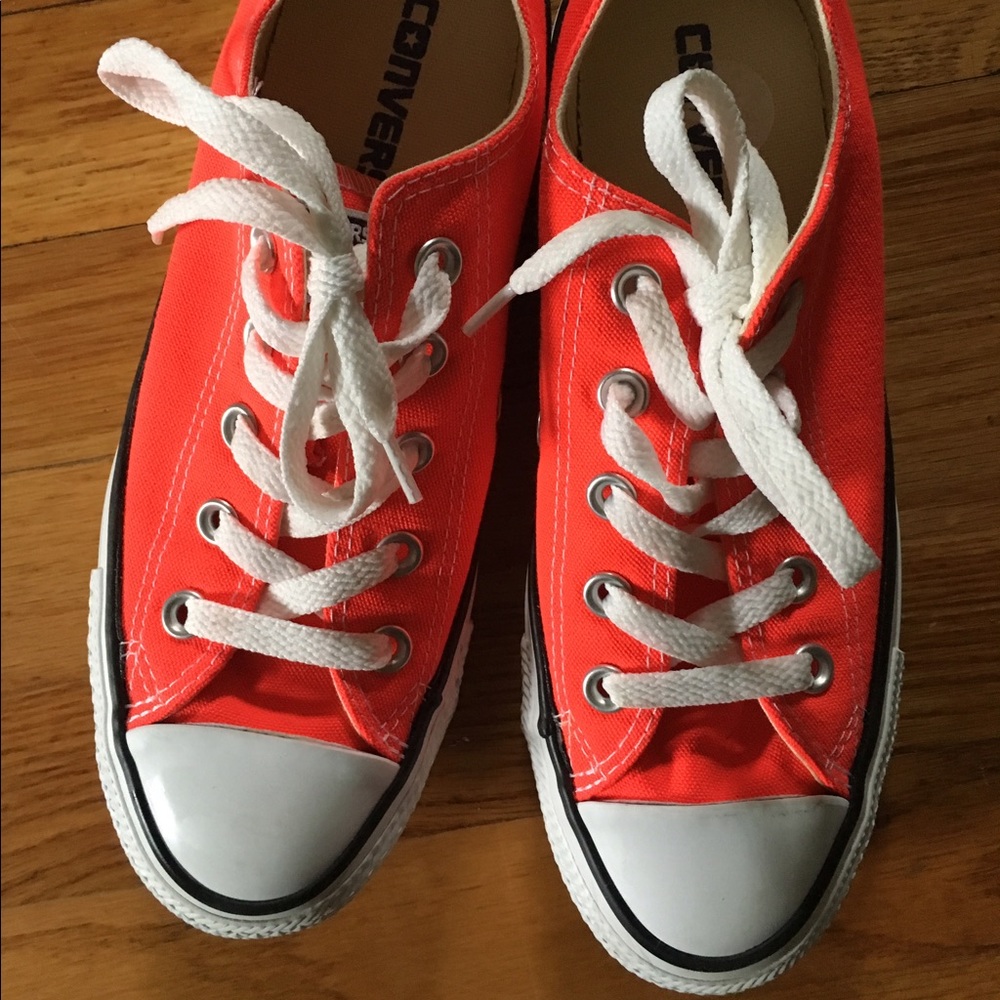 Converse neon orange low tops.