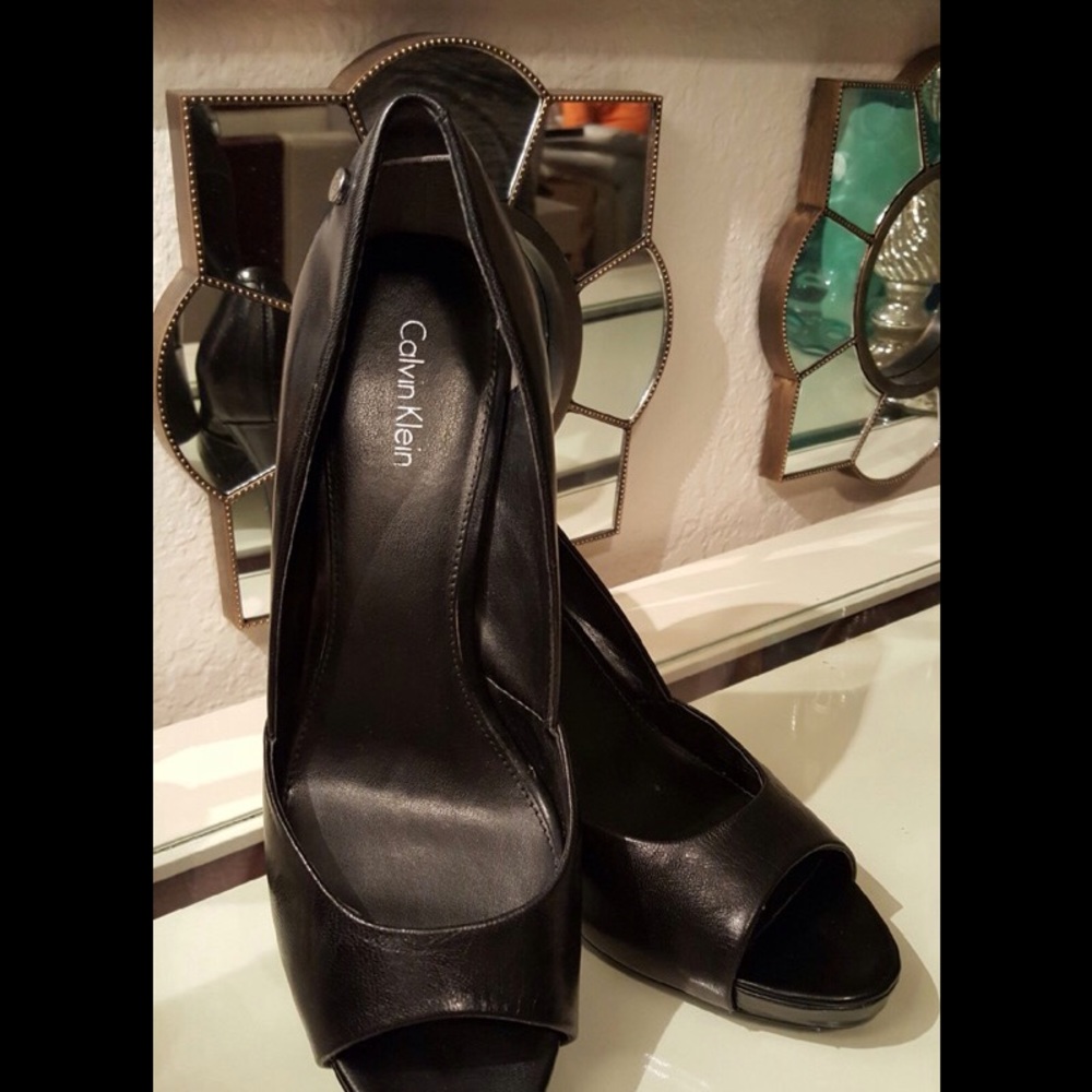 Black leather pump with open toe.