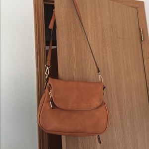 A tarnish colored cross over bag