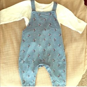 Blue overalls with white long sleeve shirt.