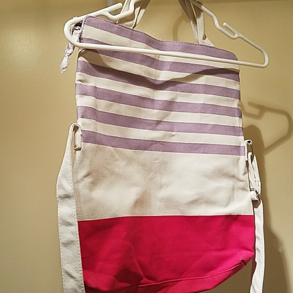 White purple and pink bag, zips closed. Adjustable
