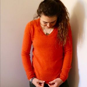 A cashier autumn orange sweater bought at Saks