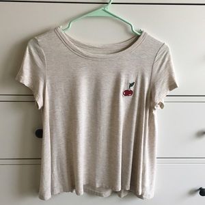 Cute cream loose graphic tee with cherry patch.