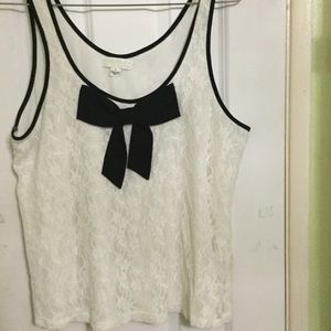 White lace top with black trimming and a black bow