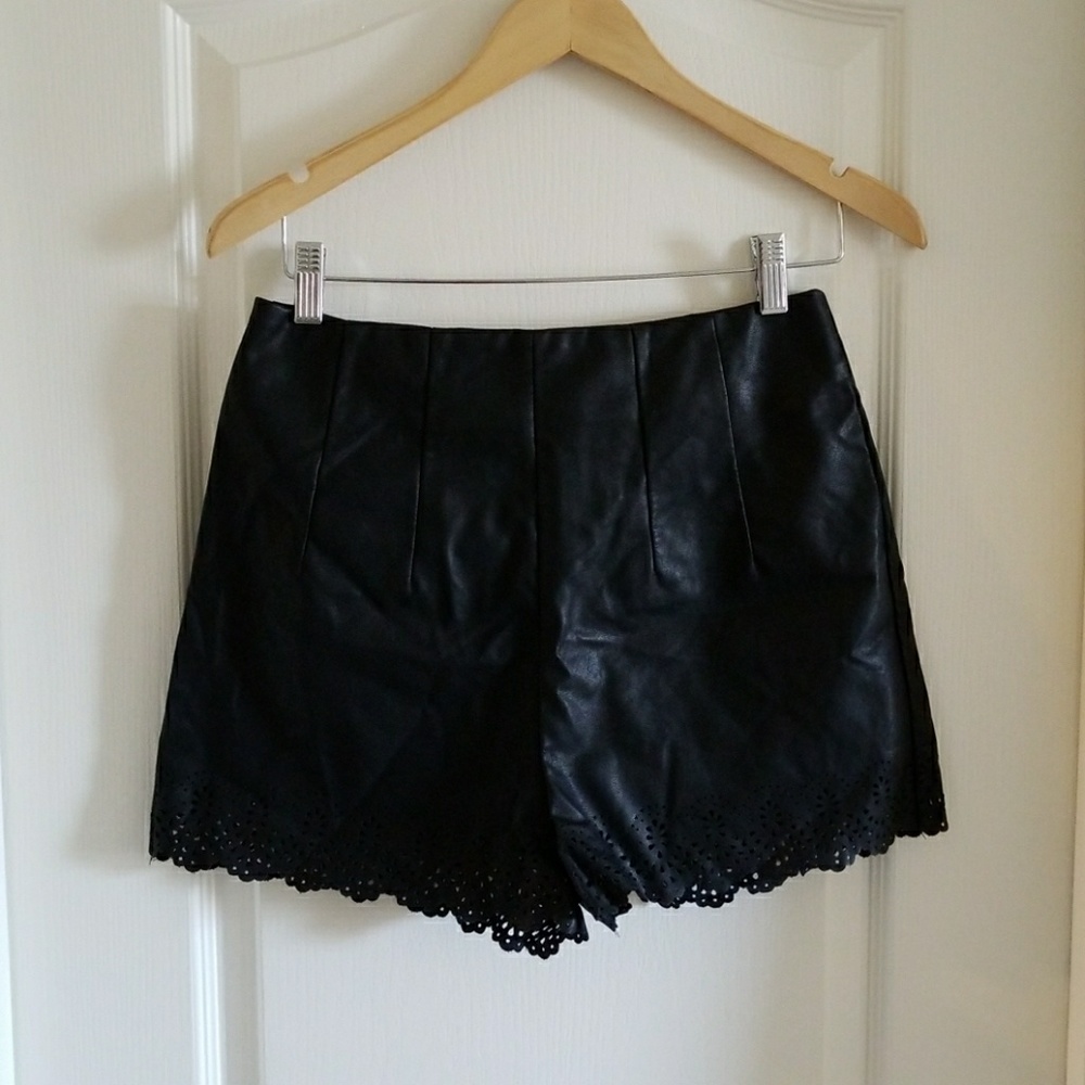 Black faux leather laser cut shorts.