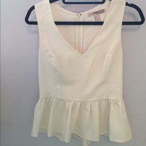 Cream colored peplum shirt with subtle pattern