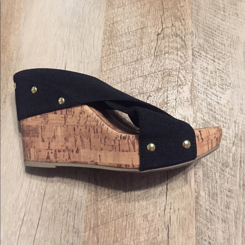 Black and cork platform heels with gold accents.