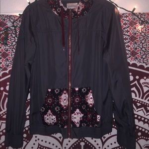 Grey windbreaker w/ patterned pockets and hood.