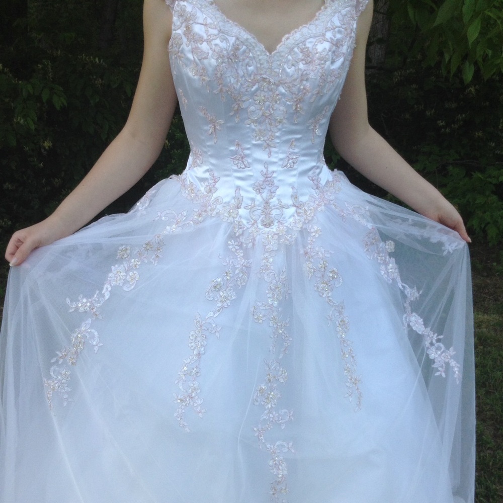 White prom dress with pink flower embellishments.