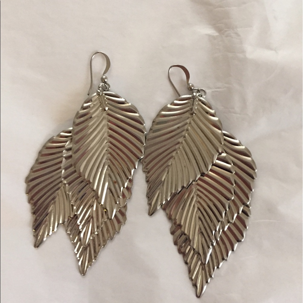 Silver color dangle earrings. Leaf shape.