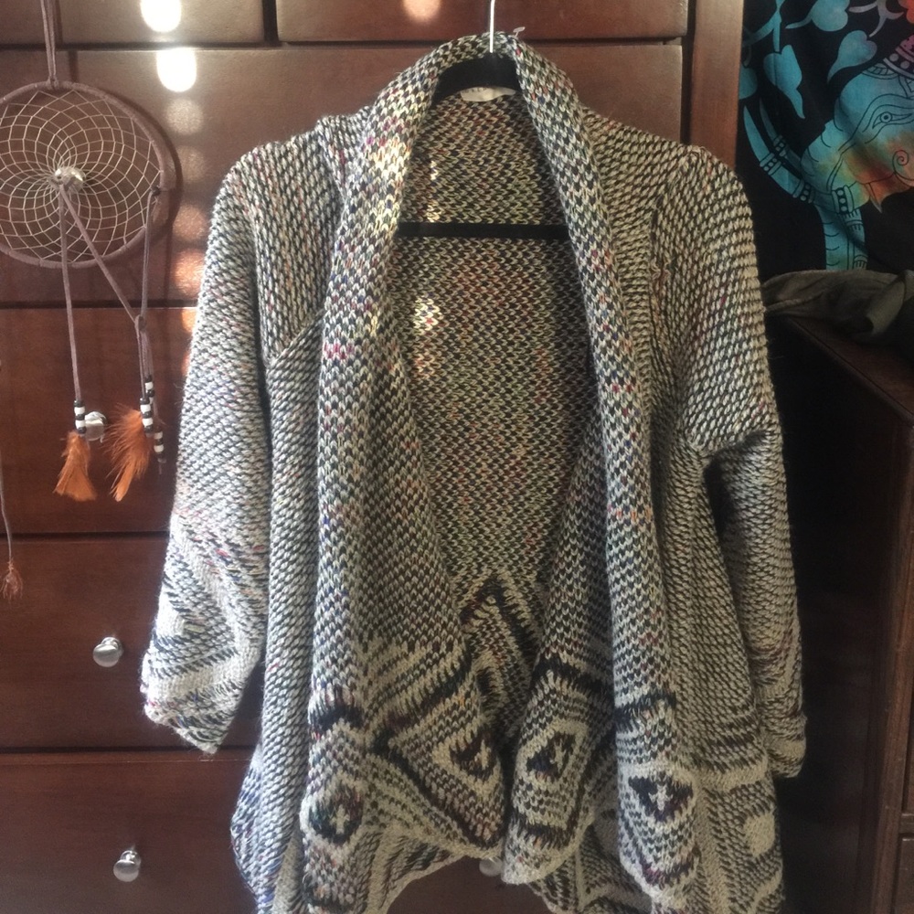 Long beige cardigan with colored details.