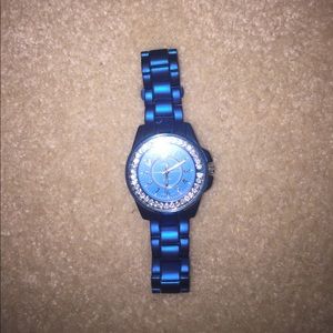 Blue stainless steel watch diamonds around face.