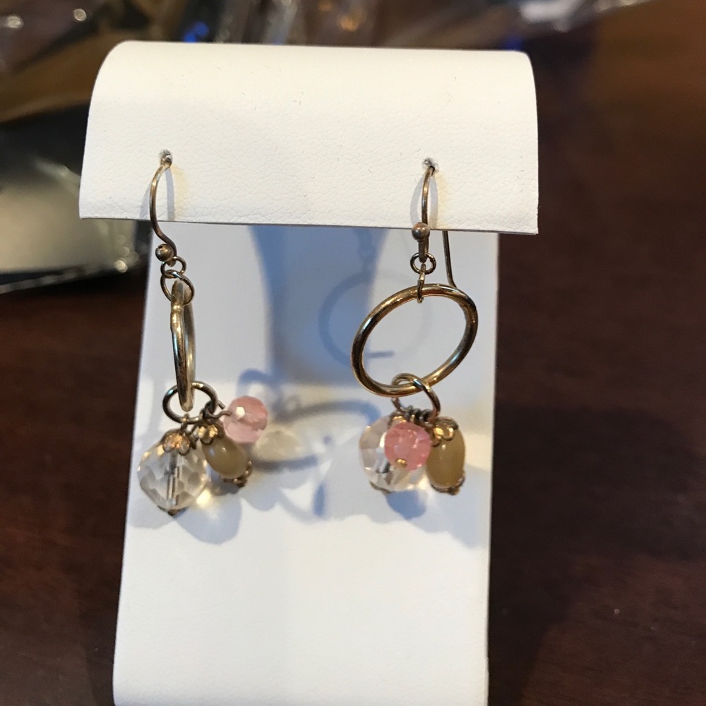 Dangling gold tone earrings.