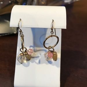 Dangling gold tone earrings.