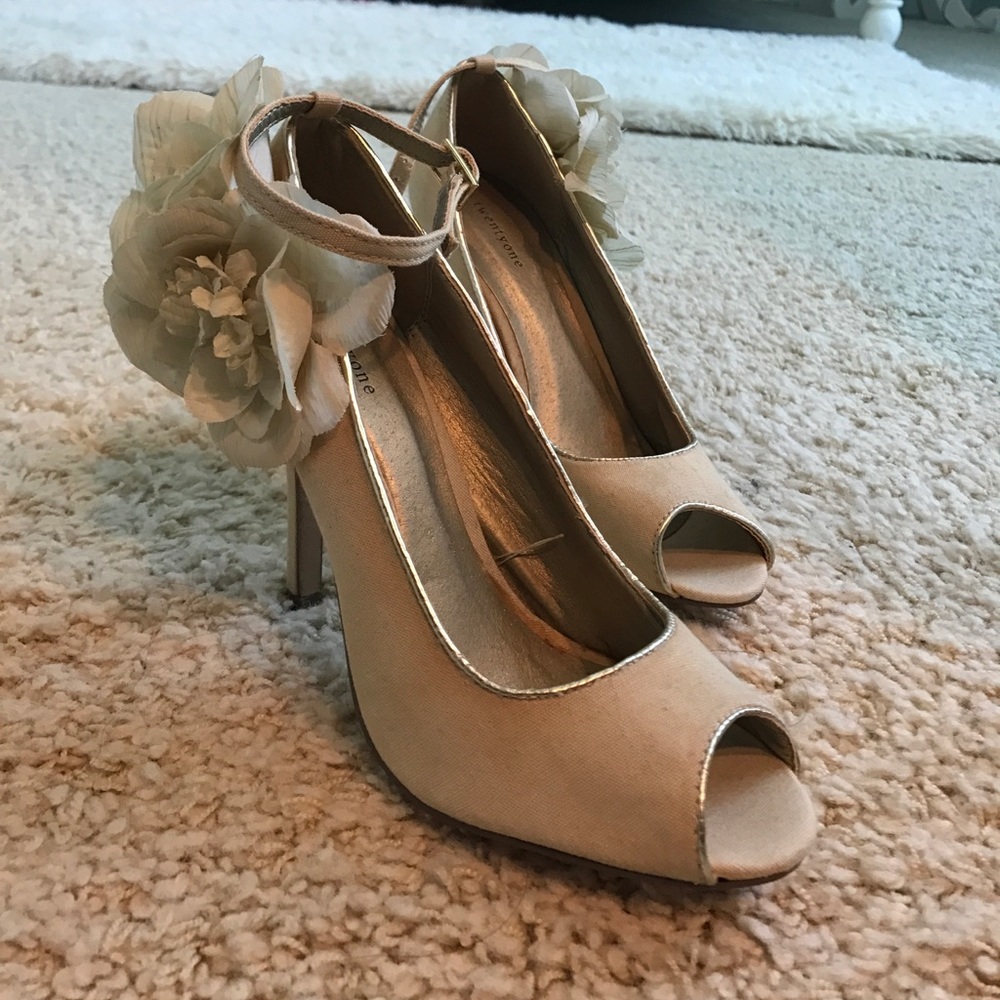 Cream colored heels with flower accent.