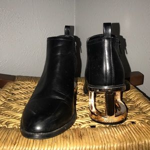 Black, faux leather booties with gold caged heel.