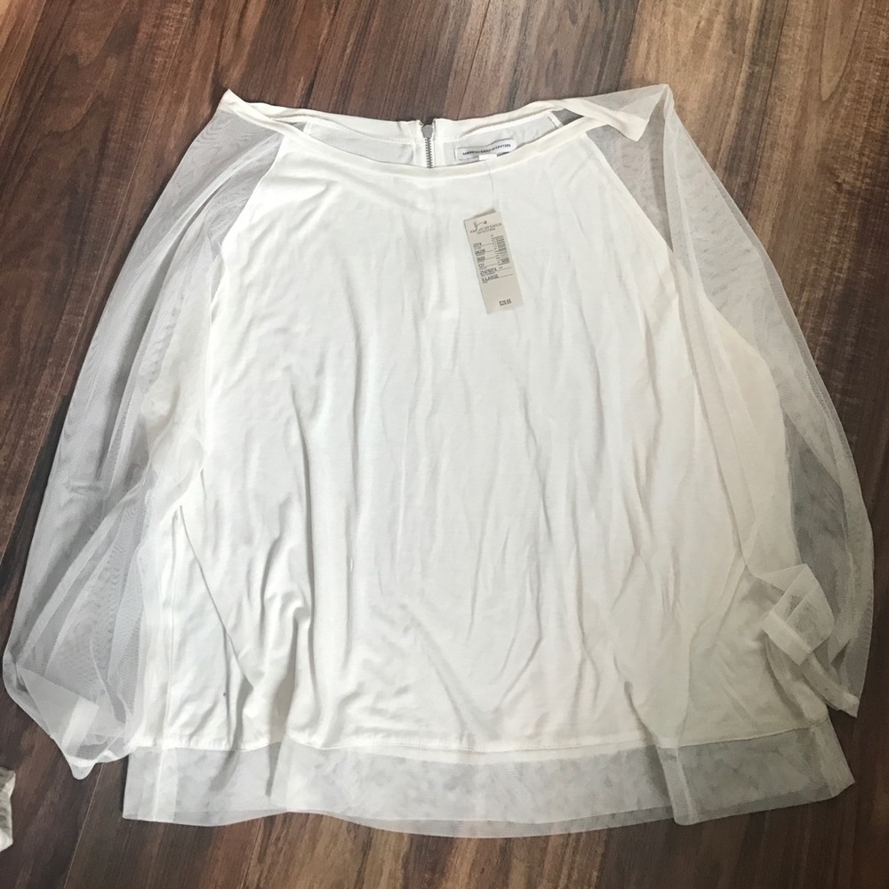 Cream top with zipper back and mesh sleeves.