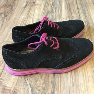 A black dress shoe with pink bottom and laces