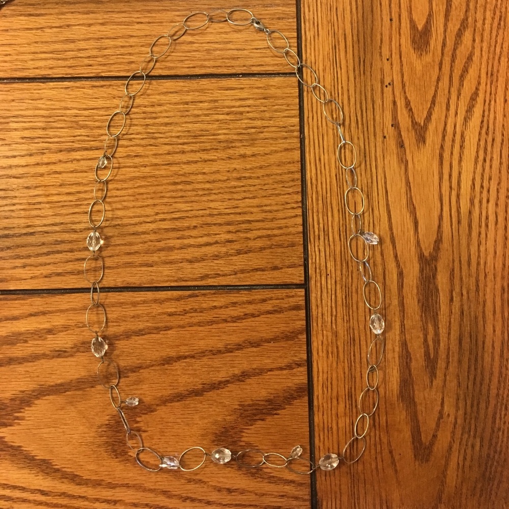 Long silver necklace with bead detailing.
