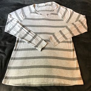Long sleeved grey and light grey striped shirt.
