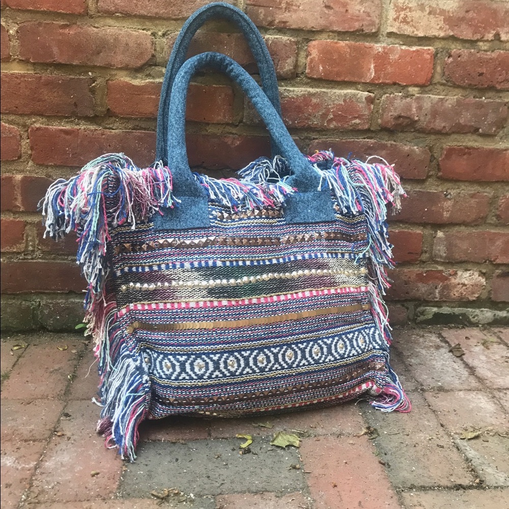 Denim tote bag with fringes and studs .