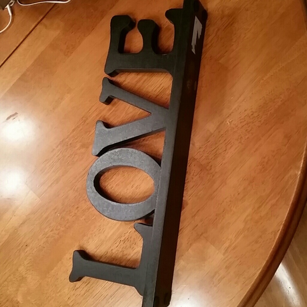 Black wooden sign featuring the word 'Love'