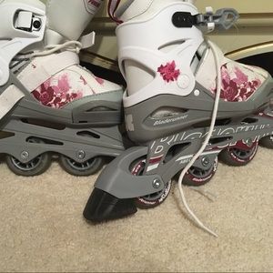 White rollerblades that have pink flowers