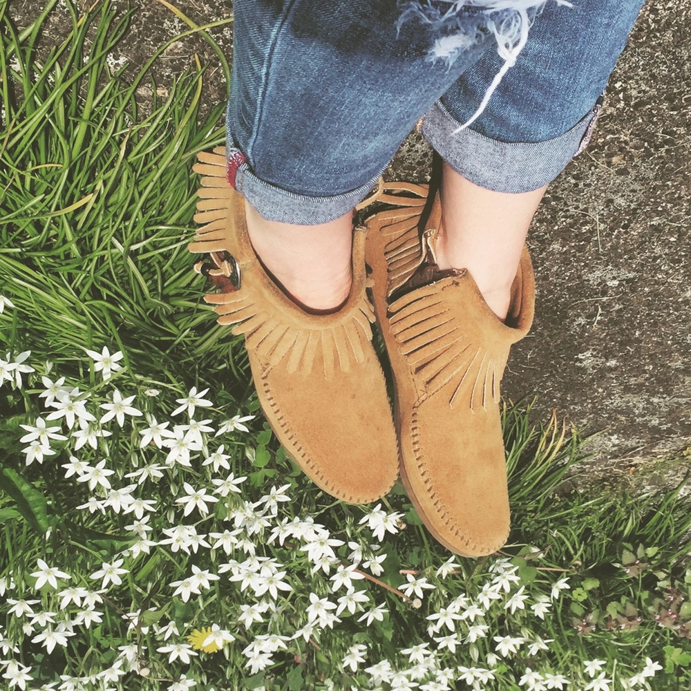 Tan Minnetonka moccasins with feather detail