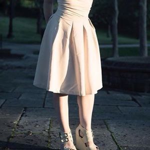 Gently pleated beige bubble-hem bell-shaped skirt