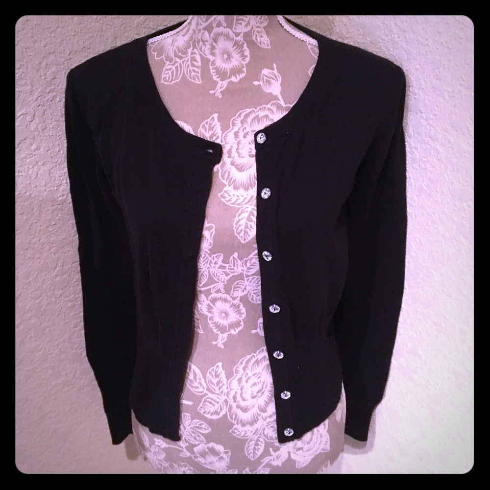 Black sweater with diamond buttons.