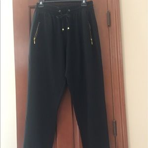 Black pants with gold front pockets zippers