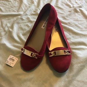 Red flats with gold embellishment on top.