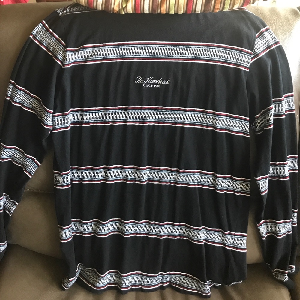 A hundreds sweater with blue white and red stripes
