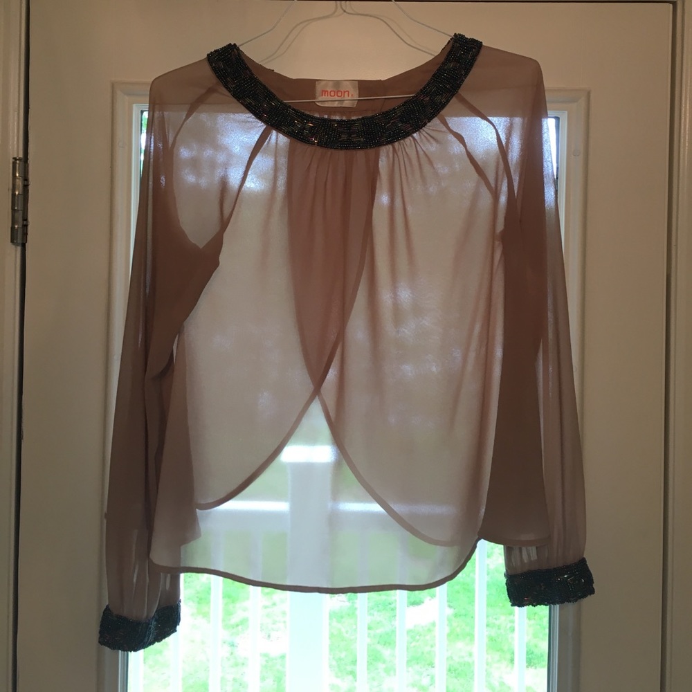 Backless blouse with beaded neckline and cuffs.
